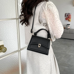 Fashionable black leather crossbody bag with metal ring buckle and twisted handle
