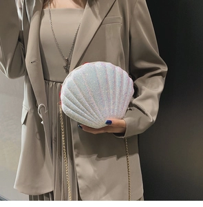 Detail of shell-shaped crossbody bag with iridescent sequins and gold chain strap