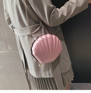 Chic pink shell-shaped bag with gold chain strap and elegant pearl zipper detail