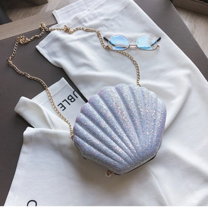 Detail of purple sequin shell bag featuring a shimmering texture and gold chain strap