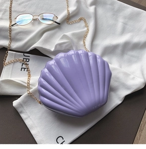 Close-up of pearl purple shell-shaped acrylic crossbody bag with gold chain strap
