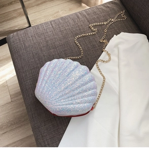 Detail of shell-shaped crossbody bag with iridescent sequins and gold chain strap