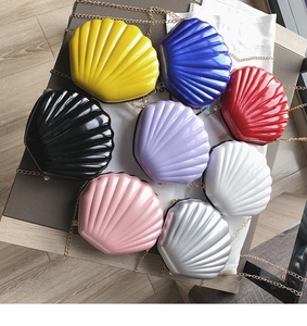 Detailed overhead view of multiple colorful shell-shaped chain bags with glossy texture