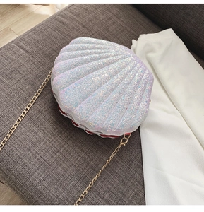 Detailed top view of sequined shell cross-body bag with golden chain and red piping