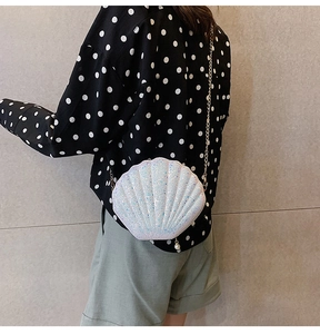 Close-up of shell-shaped crossbody bag with iridescent sequins and gold chain strap