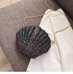 Detailed top view of black sequin shell-shaped bag with pearl clasp and gold chain