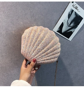 Detail of pink sequin shell bag with fine metal chain and delicate pearl pendant accessory