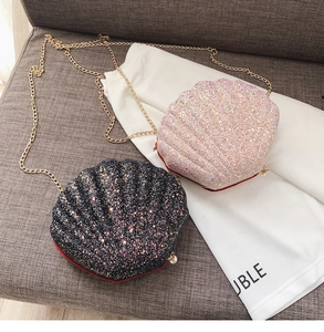 Detail of shell-shaped crossbody bags with shimmering sequins and gold chain strap