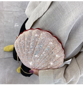 Detailed shot of a shell-shaped crossbody bag with champagne sequins and gold chain strap