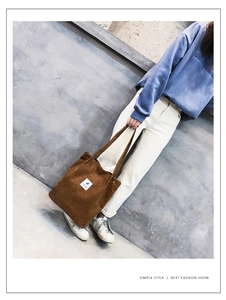 Gros plan du sac cabas en velours côtelé marron avec étiquette sur sweat bleu