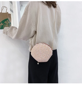 Detail of pink glitter shell cross-body bag with gold chain strap and pearl charm