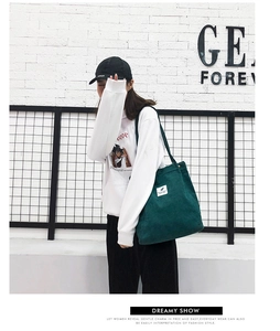 Détail du sac fourre-tout en velours côtelé vert foncé avec texture épaisse et bouton métal