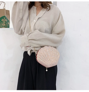 Detail of shell-shaped crossbody bag with pink sequins and elegant gold chain strap