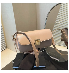 Dettaglio della borsa a tracolla in pelle beige con elegante fibbia dorata rettangolare