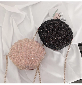Detail view of shell-shaped glitter bags in black and pink gold with gold metal chains