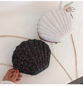 Close-up of glitter seashell crossbody bags with metallic chain straps in black and white