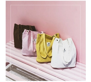 Texture détaillée des sacs fourre-tout en velours côtelé marron, rose, jaune et blanc