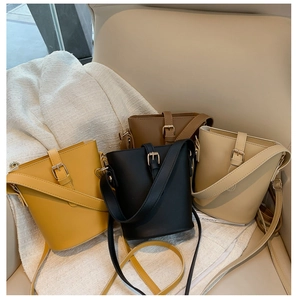 Chic bucket bags in yellow, black, beige, and brown on a soft fabric display