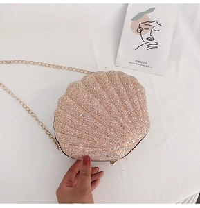 Detail shot of shell-shaped crossbody bag with pink sequins and gold chain strap