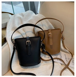 Detail view of black and brown leather bucket bags with adjustable shoulder straps