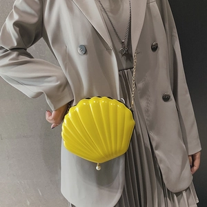 Bright yellow shell-shaped acrylic crossbody bag with gold chain and pearl charm