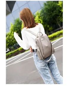 Taupe waterproof nylon backpack for women shown in an outdoor street lifestyle setting