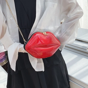 Fashionable red lip shaped crossbody bag with gold chain strap worn over white shirt