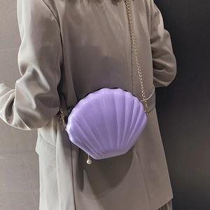 Lavender shell-shaped crossbody bag with glossy texture and gold chain strap