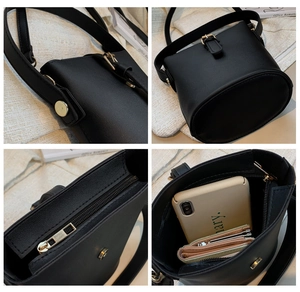 Detail view of black bucket bag featuring adjustable strap, zipper, and interior capacity
