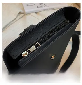 Detail of smooth black leather bucket bag with metal zipper and magnetic closure