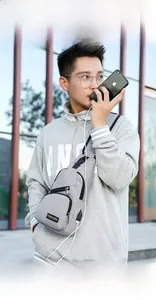 Outdoor view of gray crossbody chest bag with integrated USB charging port on side