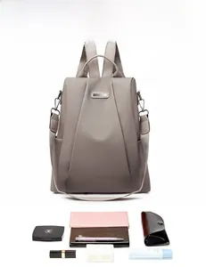 Detailed internal capacity showing gray nylon backpack holding phone, wallet, and cosmetics