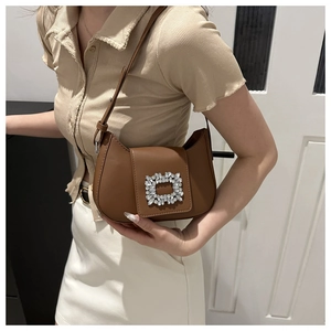 Détail du sac demi-lune caramel avec boucle en cristal étincelant et fine bandoulière chic