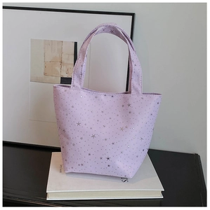 Detail of purple tote bag with silver sequin stars on textured fabric surface