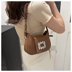 Détail du sac porté épaule en cuir marron avec boucle carrée ornée de strass brillants