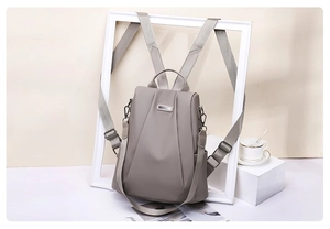 Detail view of water-resistant nylon backpack with top handle and metal logo plate