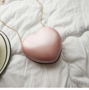 Detailansicht einer rosa herzförmigen Minitasche mit Perleffekt und goldener Kette