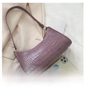 Detailed close-up of purple faux crocodile pattern leather with gold metal hardware buckle