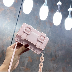 Roze mini-crossbodytas met dubbele gespen en een grove decoratieve harsketting