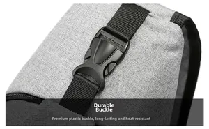 Macro detail of a durable black plastic buckle on a gray oxford fabric crossbody bag