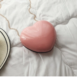 Detailansicht einer rosa herzförmigen Mini-Tasche mit Glanzeffekt und goldener Kette