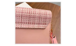 Close-up of pink tweed texture and embroidered floral strap on a chic shoulder bag