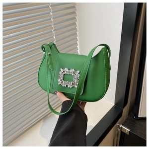 Détail d'un sac demi-lune vert vif en cuir avec une boucle en cristal de luxe