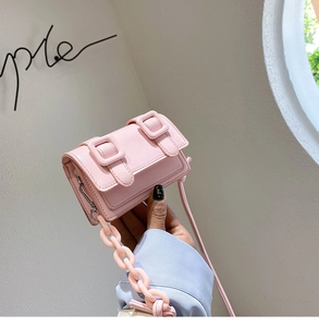 Detailopname van roze mini vierkante tas met harsketting en dubbele gespsluiting