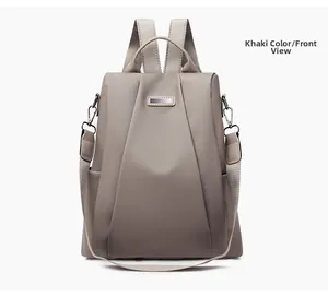 Front view of khaki waterproof nylon backpack with adjustable straps and metal logo plate