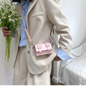 Detailopname van een roze mini-Cambridge-tas met plastic ketting en glanzend kunstleer