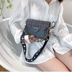Close-up of woven tweed crossbody bag with golden chain and daisy print wide strap