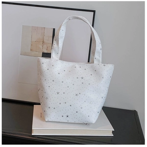 Detailed close-up of white canvas tote bag featuring metallic silver star prints