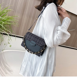 Detail of tweed crossbody bag with gold chain strap and black leather panel