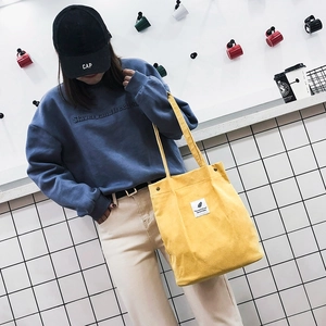 Sac fourre-tout en velours côtelé jaune avec écusson plume vintage dans un cadre décontracté